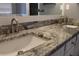 Close up on a bathroom double vanity with gray granite countertops and modern brushed-nickel faucets at 9130 Laws Rd, Clermont, FL 34714