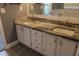 Bathroom featuring a double vanity with granite countertops, white cabinetry, and modern fixtures at 9130 Laws Rd, Clermont, FL 34714