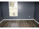 Bedroom featuring hardwood floors, windows with blinds, and neutral gray paint at 9130 Laws Rd, Clermont, FL 34714