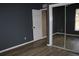 Bedroom featuring hardwood floors, paint in neutral gray, and closet with sliding mirror doors at 9130 Laws Rd, Clermont, FL 34714