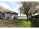 Home exterior showcasing a lush lawn, mature trees, and lake view at 9130 Laws Rd, Clermont, FL 34714