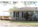 Charming single-story house featuring a covered patio, dark shutters, and lush landscaping at 9130 Laws Rd, Clermont, FL 34714