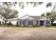 Charming single-story home with a grey exterior, a boat port, and lush landscaping at 9130 Laws Rd, Clermont, FL 34714
