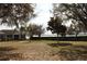 Charming single-story home with a well-maintained lawn and mature trees, offering serene lake views at 9130 Laws Rd, Clermont, FL 34714