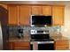 A kitchen featuring stainless steel appliances, oak cabinets, and a tiled backsplash at 9130 Laws Rd, Clermont, FL 34714
