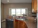 Kitchen sink area showcasing wood cabinets, granite counters, and a view of the lake at 9130 Laws Rd, Clermont, FL 34714