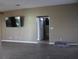 Cozy living area with a mounted TV, tile flooring, and access to other rooms, creating a seamless flow at 9130 Laws Rd, Clermont, FL 34714