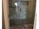 Modern shower featuring glass doors, marble tile surround, pebble floor, and brushed-nickel fixtures at 9130 Laws Rd, Clermont, FL 34714