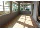 Spacious sun room with tiled floor, providing panoramic lake views through many windows at 9130 Laws Rd, Clermont, FL 34714