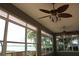 Cozy sun room with ceiling fans and large windows offering a relaxing lake view at 9130 Laws Rd, Clermont, FL 34714