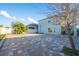 Large backyard features a brick patio, fire pit, basketball hoop, and partially shaded area at 9228 Halsey Dr, Groveland, FL 34736