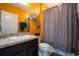 Well-lit bathroom with a dark vanity, sink, and a tiled shower with curtain at 9228 Halsey Dr, Groveland, FL 34736