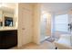 Modern bathroom featuring a glass-enclosed shower, white bench and tan tile at 9228 Halsey Dr, Groveland, FL 34736