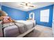 Blue bedroom with ceiling fan features a bed, dresser, and a window for natural light at 9228 Halsey Dr, Groveland, FL 34736