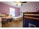 Charming bedroom with a whimsical purple wall, built-in bunk beds, and a desk for a playful atmosphere at 9228 Halsey Dr, Groveland, FL 34736