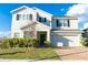 Two-story home featuring a well-maintained front yard, brick driveway, and an attached garage at 9228 Halsey Dr, Groveland, FL 34736