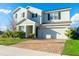 Attractive home with a brick driveway, attached garage, manicured front yard, and a welcoming entrance at 9228 Halsey Dr, Groveland, FL 34736