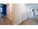Light-filled hallway with wood-look flooring and neutral walls providing access to various rooms in the home at 9228 Halsey Dr, Groveland, FL 34736