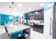 Kitchen island featuring granite countertops, stainless steel appliances, dark wood cabinetry, and access to dining area at 9228 Halsey Dr, Groveland, FL 34736