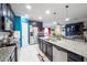 Kitchen with stainless steel appliances, granite countertops, dark wood cabinetry, and open to the living room at 9228 Halsey Dr, Groveland, FL 34736