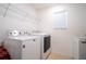Bright laundry room with large window and washer and dryer, plus overhead shelving at 9228 Halsey Dr, Groveland, FL 34736