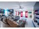 Cozy living room features plush sofa, tiled floors, ceiling fan and access to the kitchen at 9228 Halsey Dr, Groveland, FL 34736