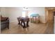 Spacious room with wood-look flooring, ceiling fan and foosball table, perfect for Gathering entertainment at 9228 Halsey Dr, Groveland, FL 34736