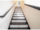 Bright staircase featuring black handrails and black and white painted stairs leading to the upper level of the home at 9228 Halsey Dr, Groveland, FL 34736