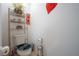 Small bathroom with toilet, decorative shelf and a modern, eye-catching toilet seat at 9228 Halsey Dr, Groveland, FL 34736