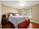 Bedroom with dark laminate flooring, neutral walls, and a bed with a wooden frame at 9236 Baton Rouge Dr, Orlando, FL 32818