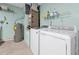 Functional laundry room with modern washer, dryer, water heater, and practical shelving for storage at 9236 Baton Rouge Dr, Orlando, FL 32818