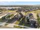 Aerial view of a well-maintained home featuring manicured lawns near a scenic lake at 938 Braewood Dr, Clermont, FL 34715