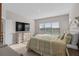 A cozy bedroom featuring a upholstered bed frame, a television and light from an external window at 938 Braewood Dr, Clermont, FL 34715