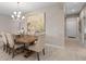 An open dining room featuring a chandelier, a wooden table with seating for six, and neutral decor at 938 Braewood Dr, Clermont, FL 34715