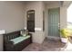 Inviting front porch featuring a bench with cushions and a potted plant by the sage-colored front door at 938 Braewood Dr, Clermont, FL 34715