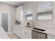 A well-lit kitchen with white cabinets, marble backsplash, quartz countertops, and stainless steel appliances at 938 Braewood Dr, Clermont, FL 34715