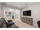 This is a living room with a television and a reclining sofa as well as an office area and access to a bathroom at 938 Braewood Dr, Clermont, FL 34715