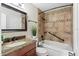 This is a neutral bathroom with stylish granite countertop, wooden cabinets, and tiled shower at 939 Framlingham Ct # 101, Lake Mary, FL 32746