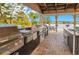 This outdoor kitchen features stainless steel grills, a sink, and a view of the lake at 1015 S Hiawassee Rd # 3514, Orlando, FL 32835