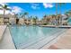 Community pool with clear water, palm trees, lounge chairs, and well-maintained surroundings at 1015 S Hiawassee Rd # 3514, Orlando, FL 32835