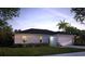 Charming single-story home showcasing lush lawn and a two-car garage under a brilliant blue sky at 1200 Apopka W Dr, Kissimmee, FL 34759