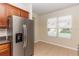 Modern kitchen with stainless steel refrigerator, wooden cabinets and natural light from window at 1201 Berkman Cir, Sanford, FL 32771