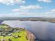 An aerial shot showcasing a scenic lakefront property with lush green lawns and an expanse of deep blue waters at 1220 Lake Mills Rd, Chuluota, FL 32766