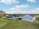 Aerial view of the home, pool, massive garage, and lush green lawn surrounded by trees on a sunny day at 1220 Lake Mills Rd, Chuluota, FL 32766