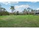 Vast green backyard with tall trees, a pond, and distant views of the home and pool area on the grounds at 1220 Lake Mills Rd, Chuluota, FL 32766