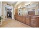 Bathroom featuring double sinks, granite countertops, and large mirrors, and view to walk-in closet at 1220 Lake Mills Rd, Chuluota, FL 32766