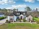 Charming home featuring stone accents, a red front door, and manicured landscaping at 1220 Lake Mills Rd, Chuluota, FL 32766