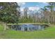 A tranquil pond has a fountain in the middle and is surrounded by greenery and trees in the backyard at 1220 Lake Mills Rd, Chuluota, FL 32766