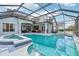 Inviting screened-in pool and spa area with ample seating and outdoor kitchen at 1220 Lake Mills Rd, Chuluota, FL 32766