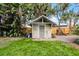 View of the backyard shed with a gray door and surrounding landscaping at 1320 Golfview St, Orlando, FL 32804